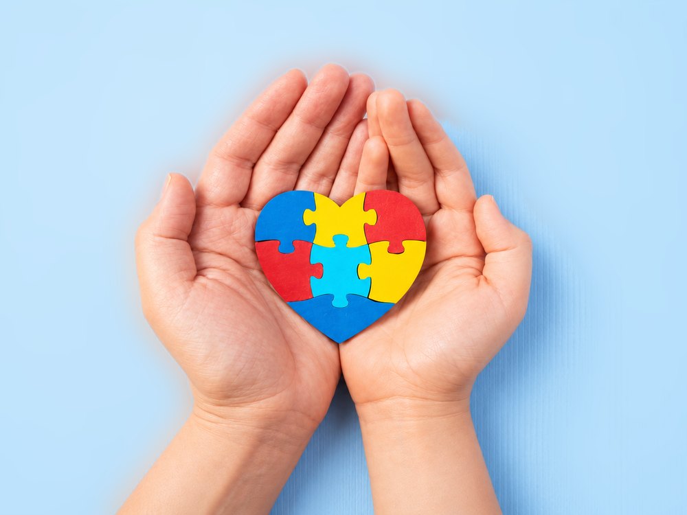 Manos sosteniendo un corazón de piezas de puzzle